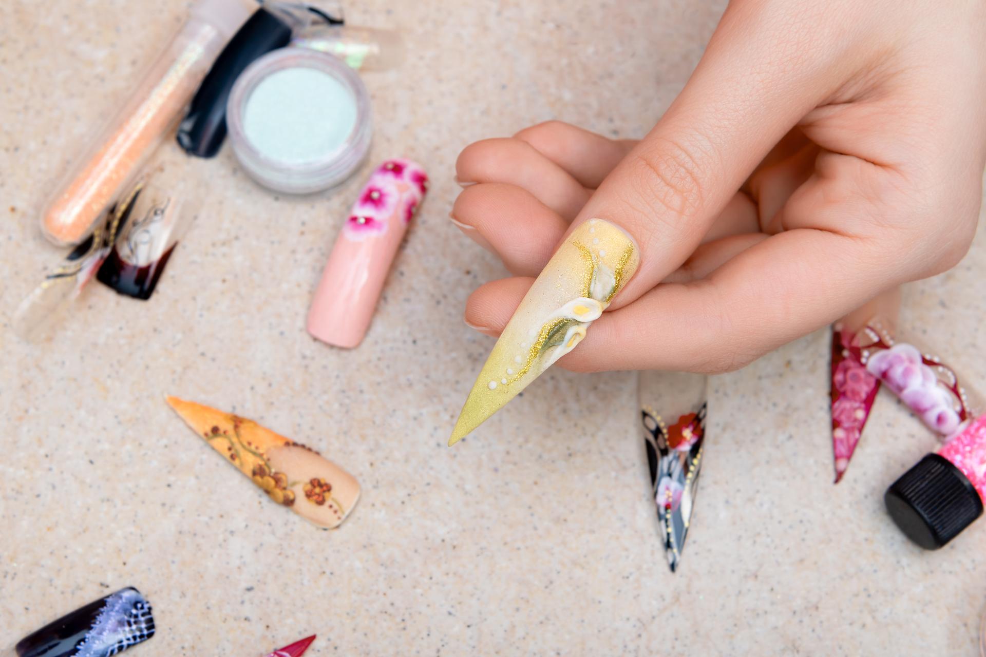Girl trying artificial nails tips with flower nail design